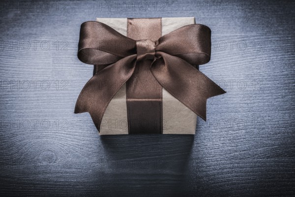 Packed gift box on vintage wooden board holiday concept