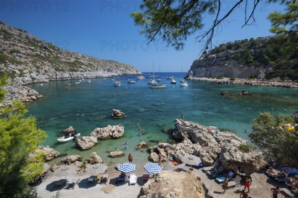 Beach umbrellas and sunbeds, turquoise waters, Anthony Quinn Bay, Faliraki, Rhodes, Dodecanese, Greece, Europe