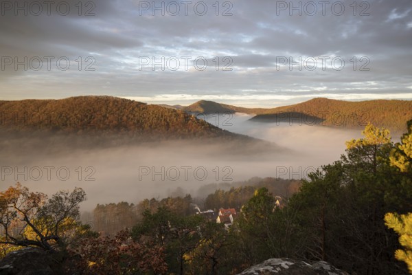 Mystical sunrise at the Wachtfelsen. Fascinating landscape shot between fog and clouds near Wernersberg, Pfälzerwald, Germany, Europe