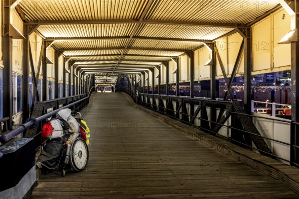 Homeless man in wheelchair in Überseebrücke, evening light, harbour, Hamburg, Germany, Europe