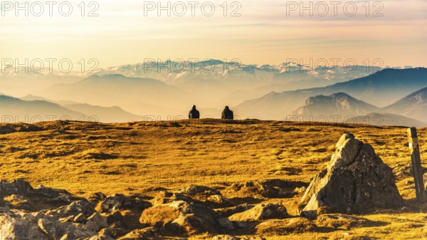 Two people enjoying view of rocky Austrian mountains from Schockl in Styria Graz. Place for tourism and hiking recreation