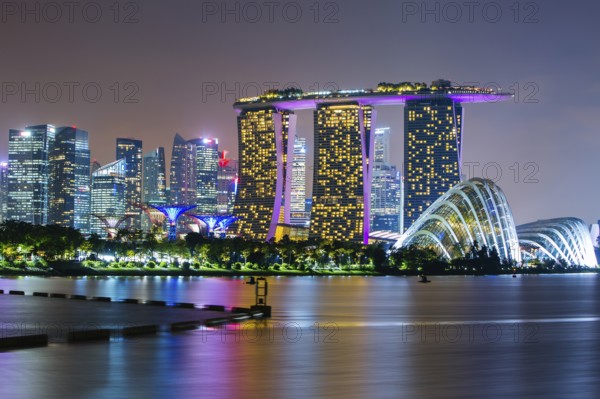 Marina Bay Sands and Gardens By The Bay with city skyline at dusk