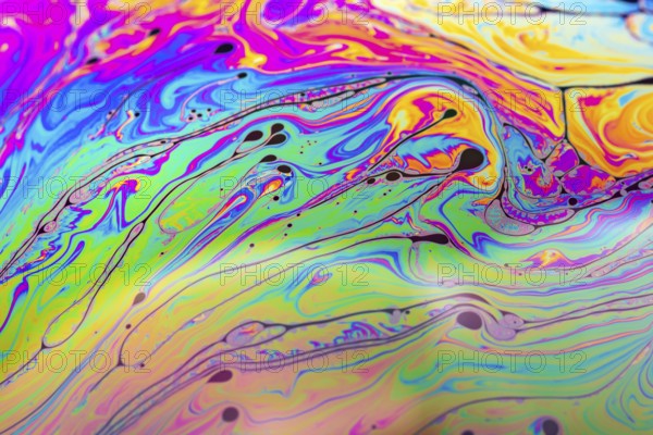 Abstract background made from soap bubble reflecting light. Rainbow soap bubble on a dark background