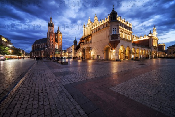 Krakow city in the evening in Poland, Main Square in the Old Town, illuminated St. Mary Church and Cloth Hall (Sukiennice)