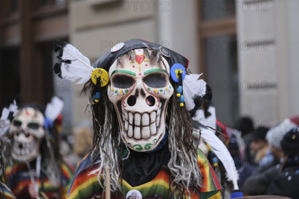 Colourful skull masks with decorative feathers in an exuberant parade