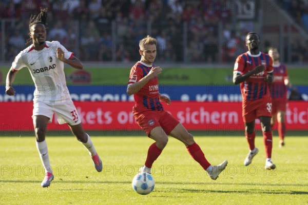 Football match, Jordy MAKENGO SC Freiburg left in a duel for the ball with Leonardo SCIENZA 1. FC Heidenheim, in the background right Sirlord CONTEH 1. FC Heidenheim, football stadium Voith-Arena, Heidenheim