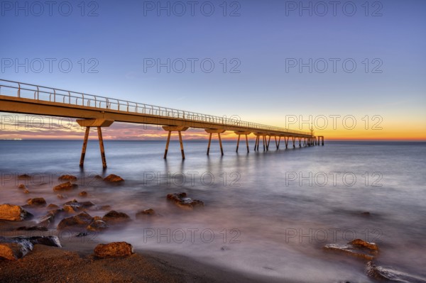 The Badalona pier, known as Pont del Petroli, in front of sunrise