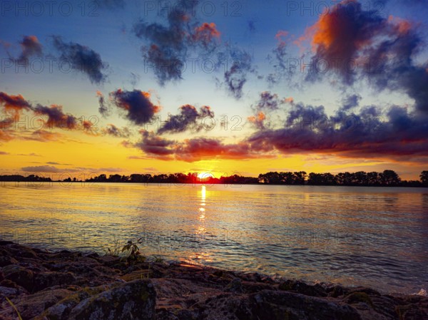 Intense sunrise with vivid colours, dramatic clouds over the water, Weserstrand 26931 Oberhammelwarden/Elsfleth-Germany