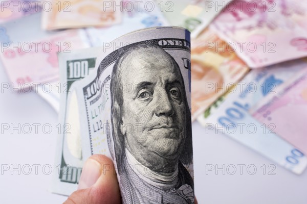 American dollar banknotes and Turksh Lira banknotes side by side on white background