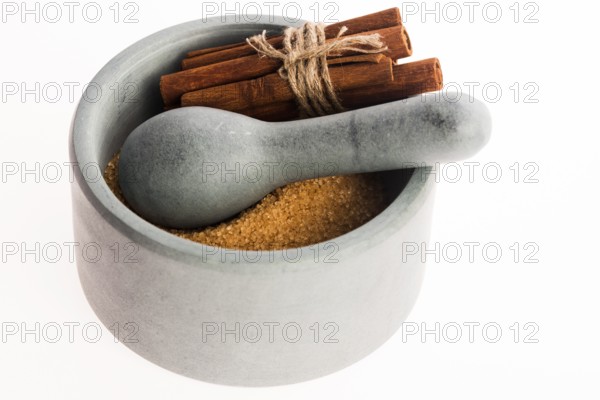 Cinnamon sticks with pure cane brown sugar in mortar