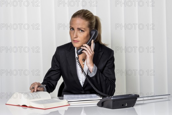 Businesswoman sitting in an office. Symbolic photo for manager, self-employed or lawyer. Austria