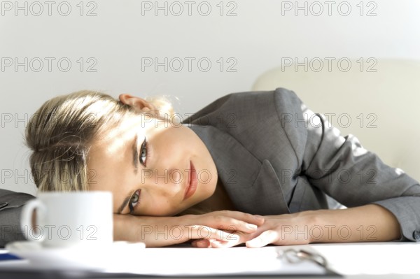 Young beautiful businesswoman sitting in the office. Break time with a cup of coffee, ST. Petersburg, Russia, Europe