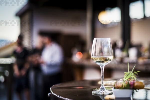 Glass of white wine with gourmet food tapa snacks in outdoors bar at sunset