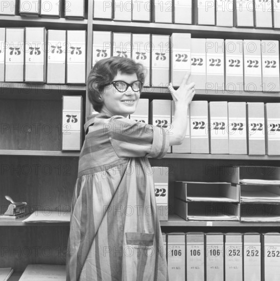 1950s glasses. A young woman in glasses and bows August 1959 is working in an archive