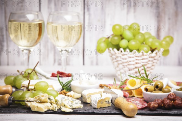 Cheese and salami on a slate board and grape wine