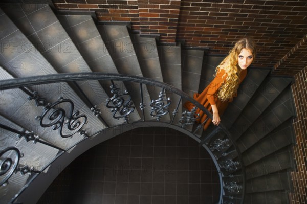 Beautiful blond woman in long dress on the stairs