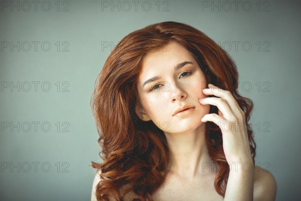 Beautiful young redhead woman with freckles portrait with curly hairdress