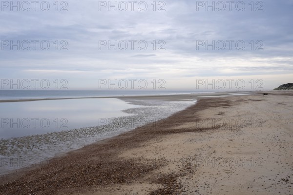 Calm beach with shallow water under a cloudy sky, Zeeland, Netherlands