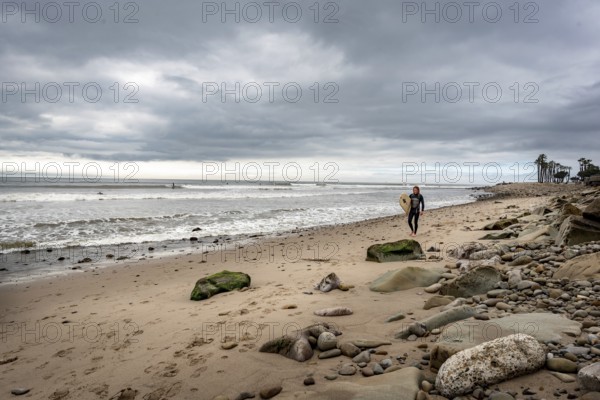 Ventura Beach, California, United States, March 1 2019: A surfer walking on the beach, North America