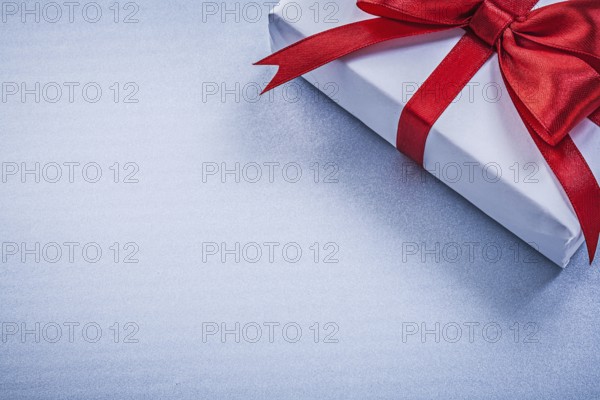 Present with red ribbon on blue background holidays concept