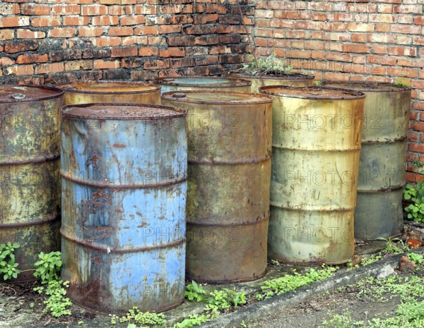 Corroding oil drums in a deserted building pollute the ground