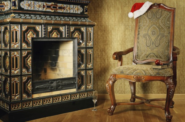 Old Antiques Armchair With Santa's Hat Near The Fireplace