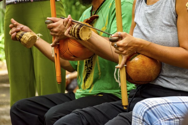 Musicians playing Afro Brazilian percussion musical instruments called berimbau during a capoeira performance in the streets of Brazil