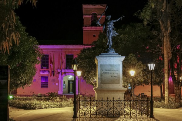 Colorful illuminated church and a statue in foreground on Freedom Square, Santa Cruz de Mompox, Colombia, World Heritage, South America