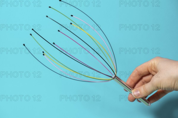 Scalp massager for home. Close up of scalp massaging brush for hair growing routine. Anti stress acupuncture metal octopus tool equipment. Manual device for home Medicine and cosmetology. SPA treatment