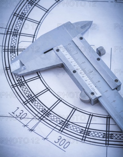 Close up of metal trammel caliper on blueprint construction concept