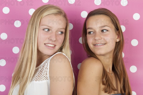 Teen girlfriends on pink background