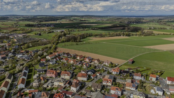 Aerial view of a neighbourhood with numerous houses and surrounding fields under a cloudy sky, Mitterteich, Upper Palatinate, Bavaria, Germany, Europe