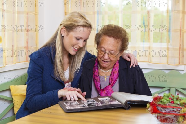 A grandson visits his grandmother Viewing the photo album. Austria