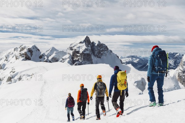 Mountaineer backcountry ski touring in the mountains. Ski touring in high alpine landscape with snowy trees. Adventure winter extreme sport.