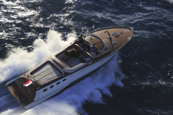 Aerial view sports boat J Craft 42 Torpedo R at full speed on the Cote d'Azur, luxurious motorboat from the Swedish shipyard J Craft Boats with Volvo Penta engine in vintage style of the 50s and 60s in the style of the Riva boats, Mediterranean Sea