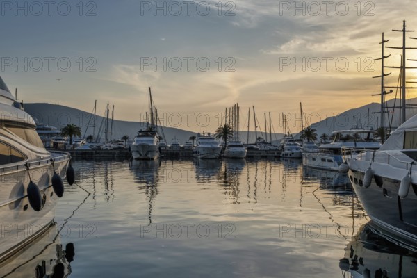 View of Harbor and marina with moored yachts and motorboats at sunset
