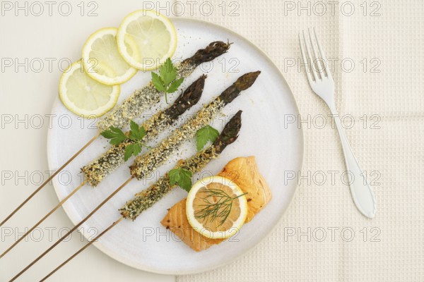 Panko-fried green asparagus on a skewer with salmon and lemon
