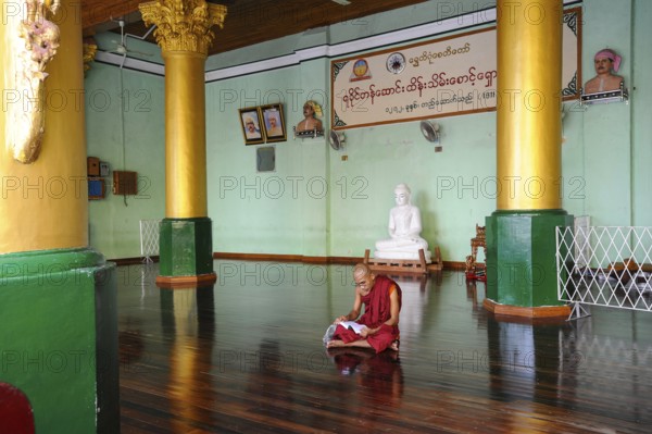 10.08.2013, Yangon, Myanmar, Asia, A Buddhist monk sits on the floor in the temple area of the Shwedagon Pagoda and reads, Asia