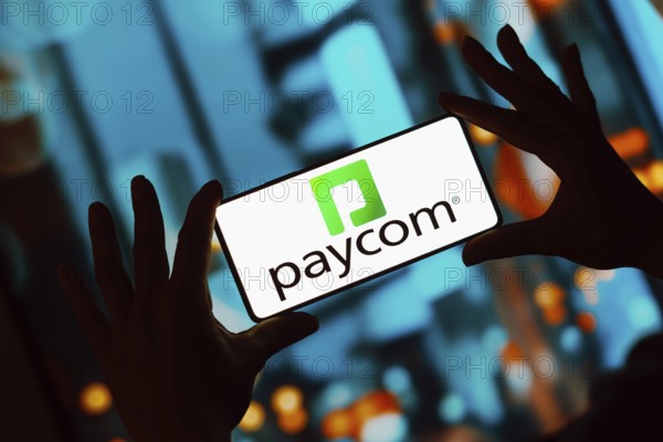 In this photo illustration, the Paycom logo is displayed on a smartphone screen