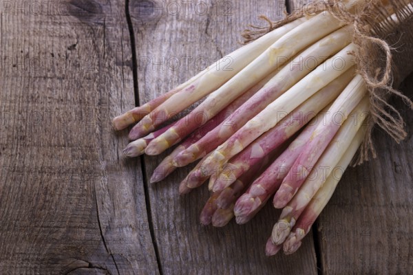 Bunch of fresh white asparagus on old wooden board