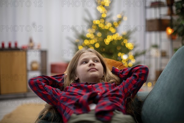 A joyful child relaxes in a cozy, warm setting, surrounded by festive decorations and glowing lights