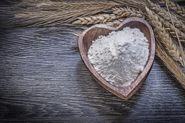 Composition of wooden bowl with flour golden rye wheat ears food and drink concept