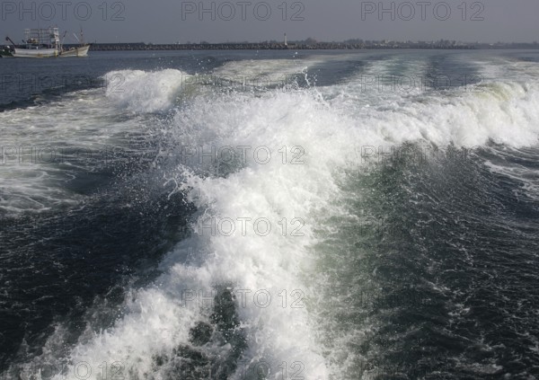 The engines of a powerful speedboat create a huge surf
