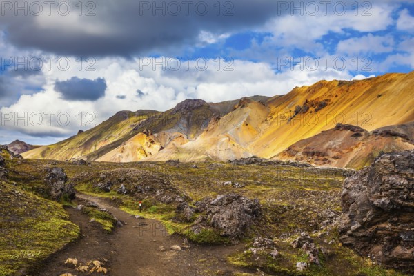 Travel to Iceland in July, volcanic summer tundra. Multi-colored rhyolite mountains - orange, yellow, green and blue