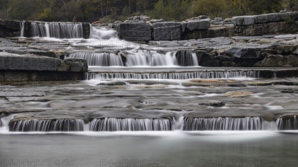 An impressive, multi-levelled waterfall flows over stones in a tranquil natural setting, Val d'Ossola, province of Verbano-Cusio-Ossola, Piedmont, Italy, Europe