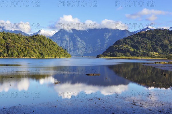 Stony shallows. A wonderful day on the river. Snow-capped mountains reflected in the smooth water. Chilean Patagonia, the road Carretera Austral