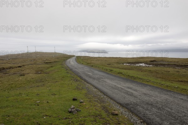 Street on the Faroe Islands in the south of Eysturoy with wind mills and nolsoy, Æduvik, Faroe Islands, Europe