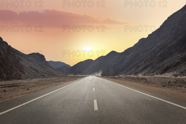 Sunrise over road through mountains in desert of Egypt