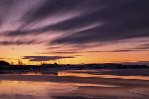 Sunset in Heidmork lake with a long exposure and clouds in moviment, Iceland, Europe