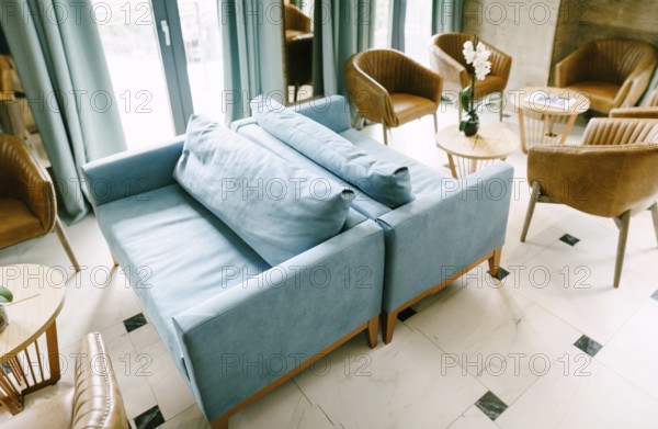 Bellagio, Italy - 07 june 2020: A large hall with blue sofas and pillows, with empty tables and chairs in the cafe